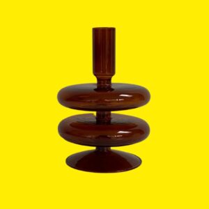 retro 70s style brown glass tapered dinner candle holder on a yellow background