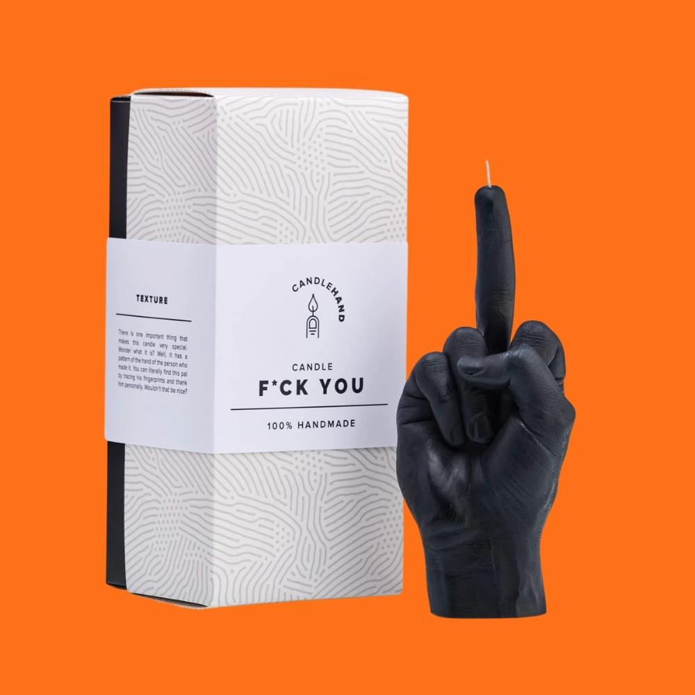 Sweary humanlike hand gesture black wax candle with gift box on an orange background