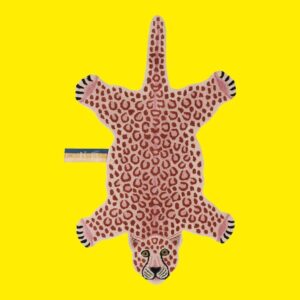 Doing Goods hand tufted rug in the shape of a pink leopard on a yellow background