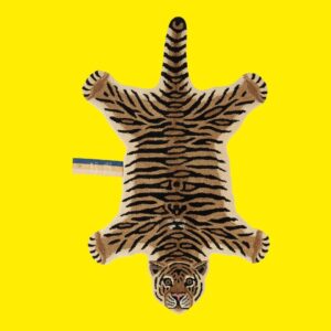 hand tufted tiger shaped animal rug on a yellow background