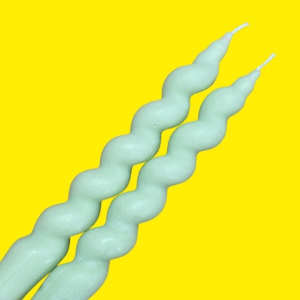 two mint twisted spiral vegan soy wax candles on a yellow background