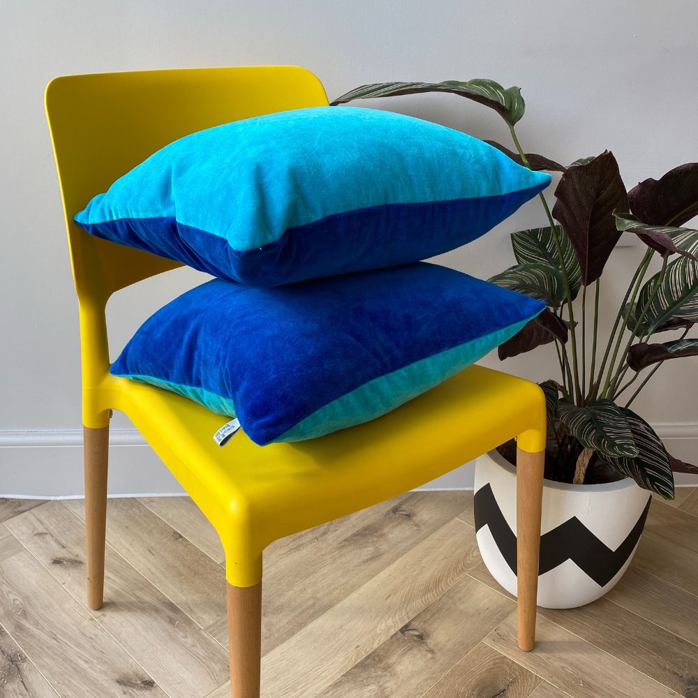 2 Two Tone Reversible Bright Blue Velvet Cushions on a yellow chair