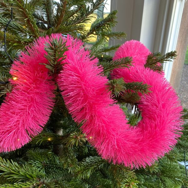 neon pink recycled plastic eco friendly tinsel garland on a Christmas tree