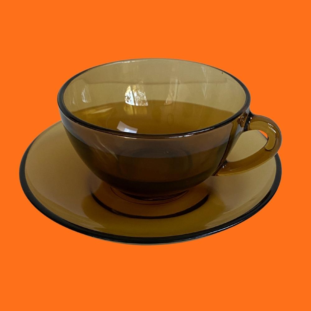 arcopal mid century retro amber smoked glass espresso cup and saucer on an orange background
