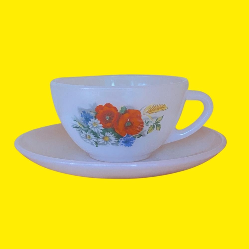 opaline white glass small espresso vintage tea cup and saucer with multicoloured floral print on a yellow background