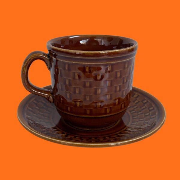 vintage mid century brown tams basket weave cup and saucer on an orange background.